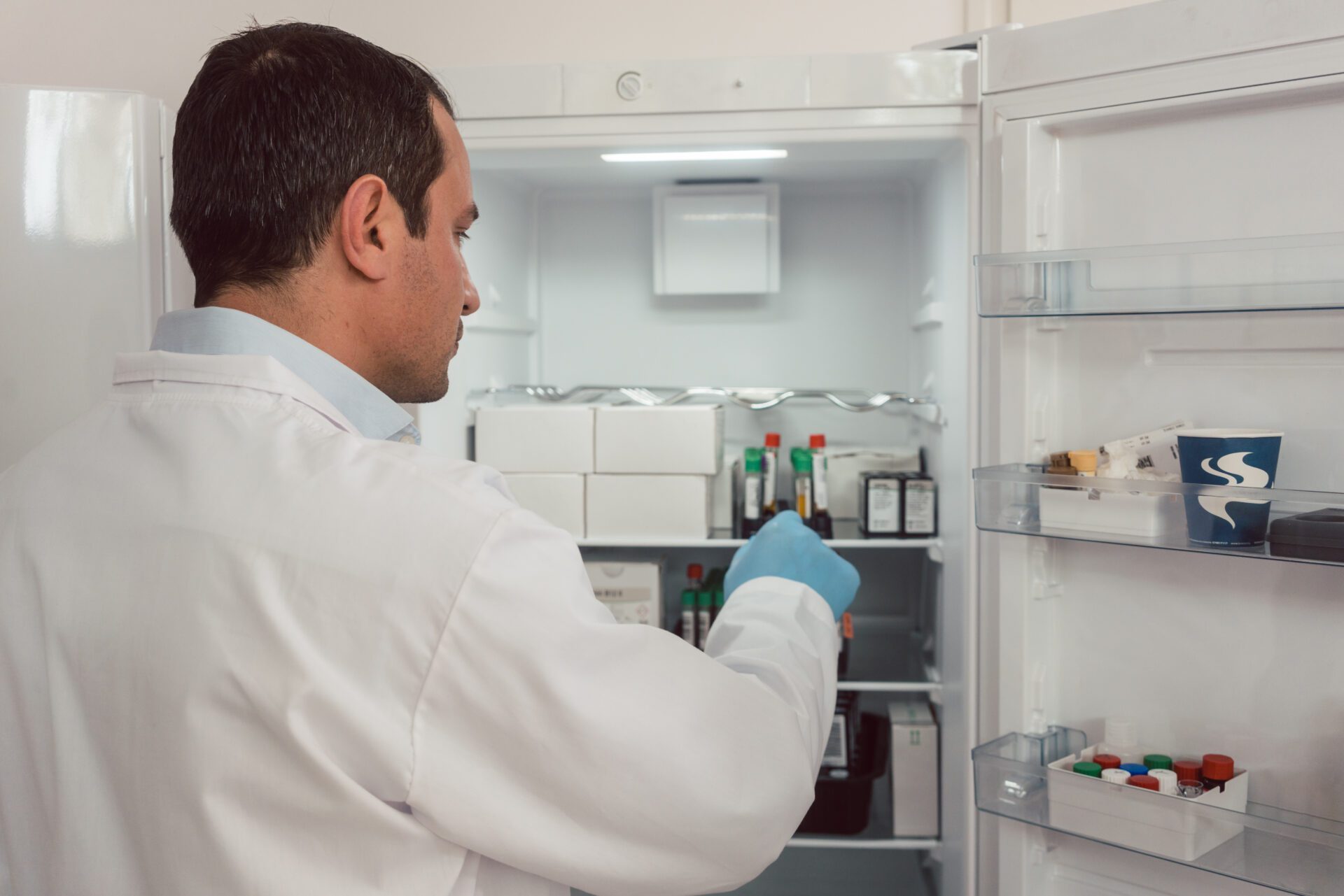 Lab technician storing blood samples in fridge